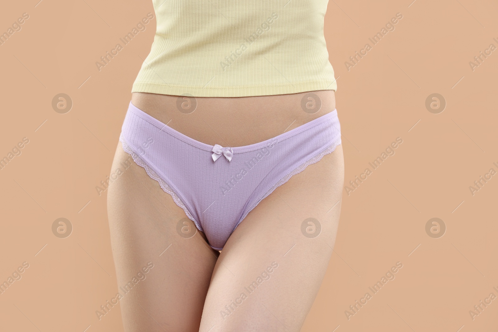 Woman wearing beautiful underwear on beige background, closeup Photo of Woman wearing beautiful underwear on beige background, closeup
