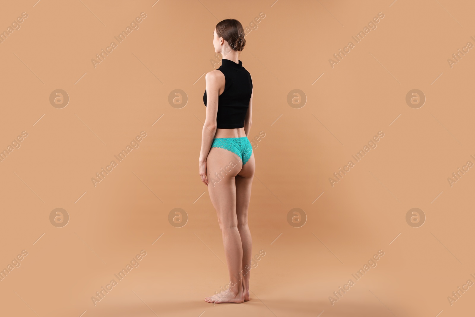 Woman wearing beautiful underwear on beige background Photo of Woman wearing beautiful underwear on beige background