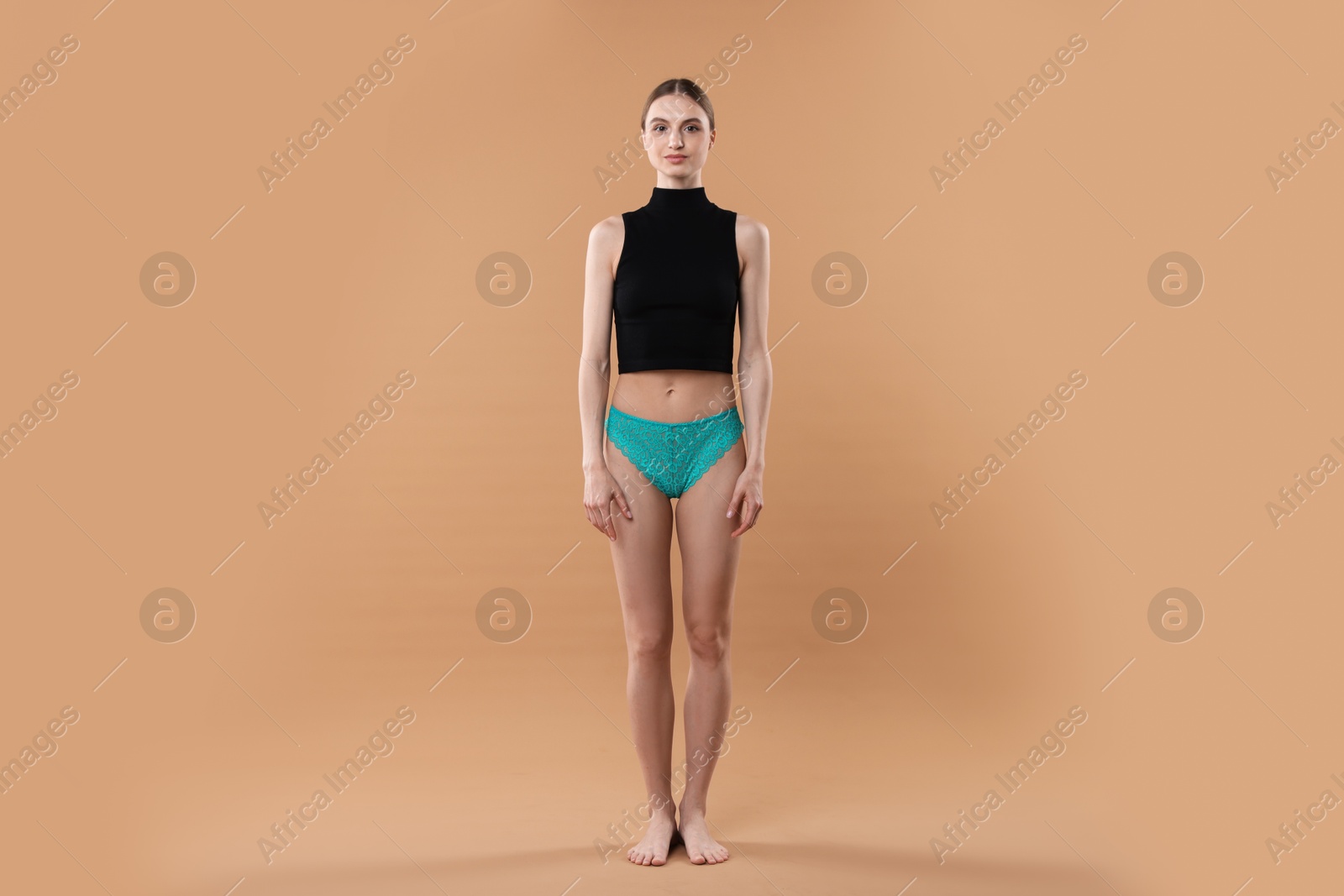 Woman wearing beautiful underwear on beige background Photo of Woman wearing beautiful underwear on beige background