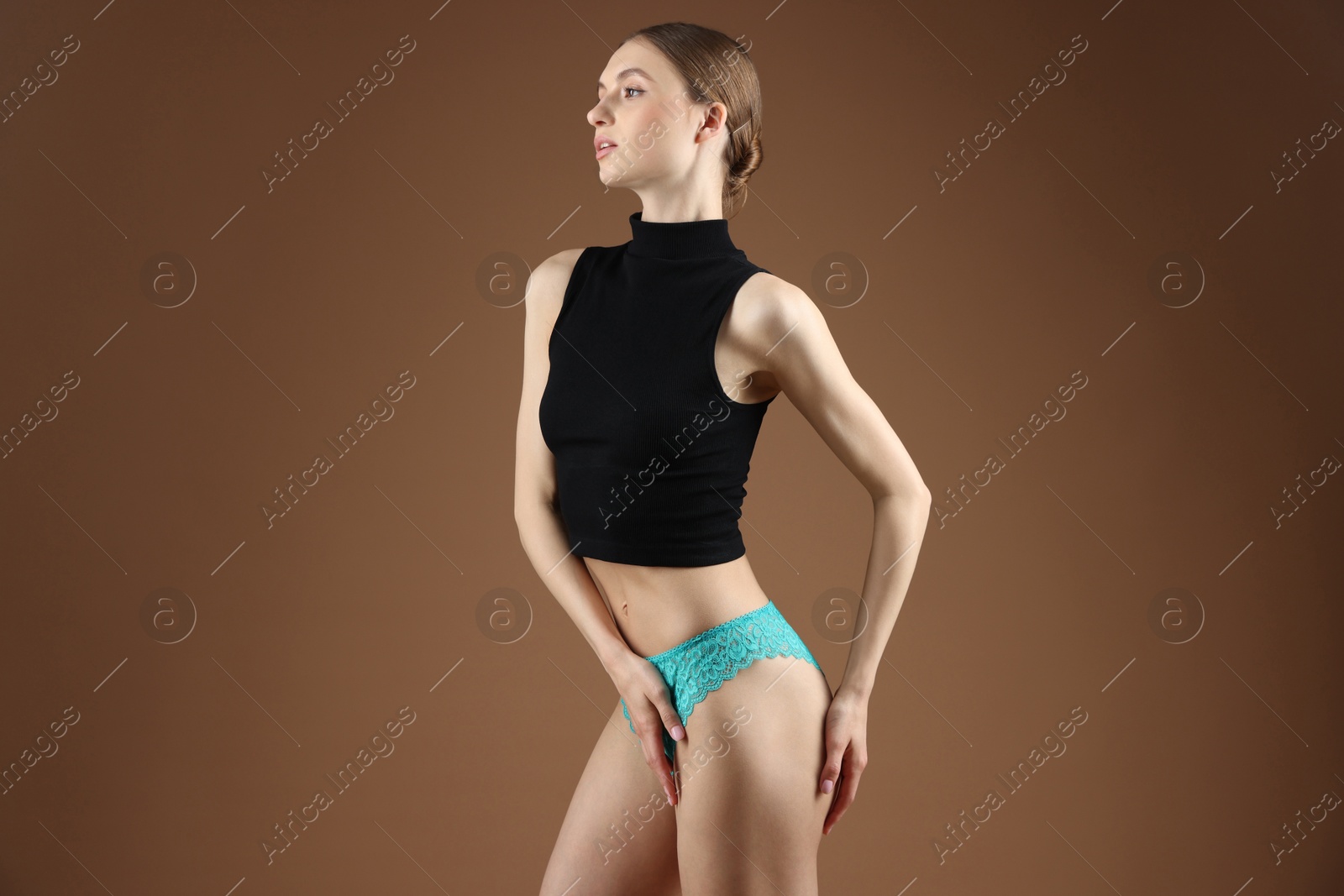 Woman wearing beautiful underwear on brown background Photo of Woman wearing beautiful underwear on brown background