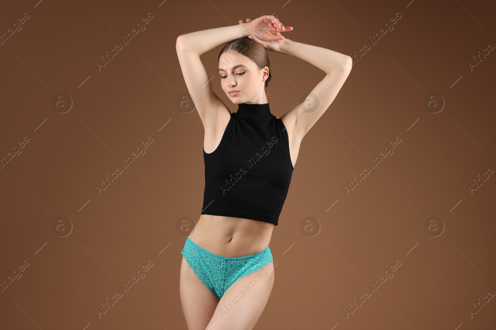 Woman wearing beautiful underwear on brown background Photo of Woman wearing beautiful underwear on brown background