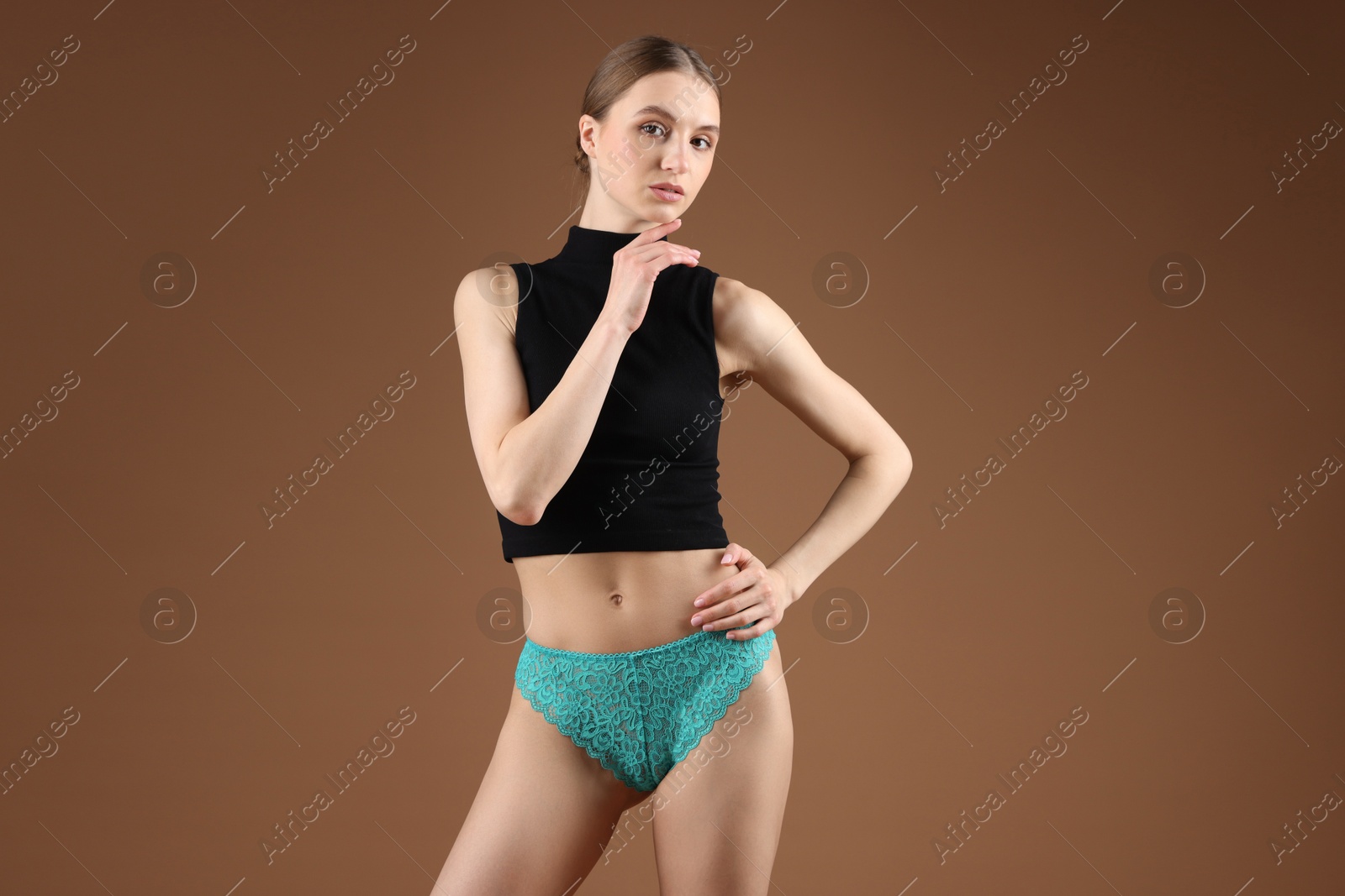 Woman wearing beautiful underwear on brown background Photo of Woman wearing beautiful underwear on brown background