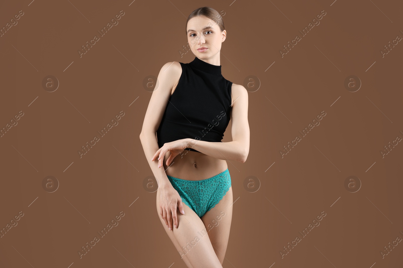 Woman wearing beautiful underwear on brown background Photo of Woman wearing beautiful underwear on brown background