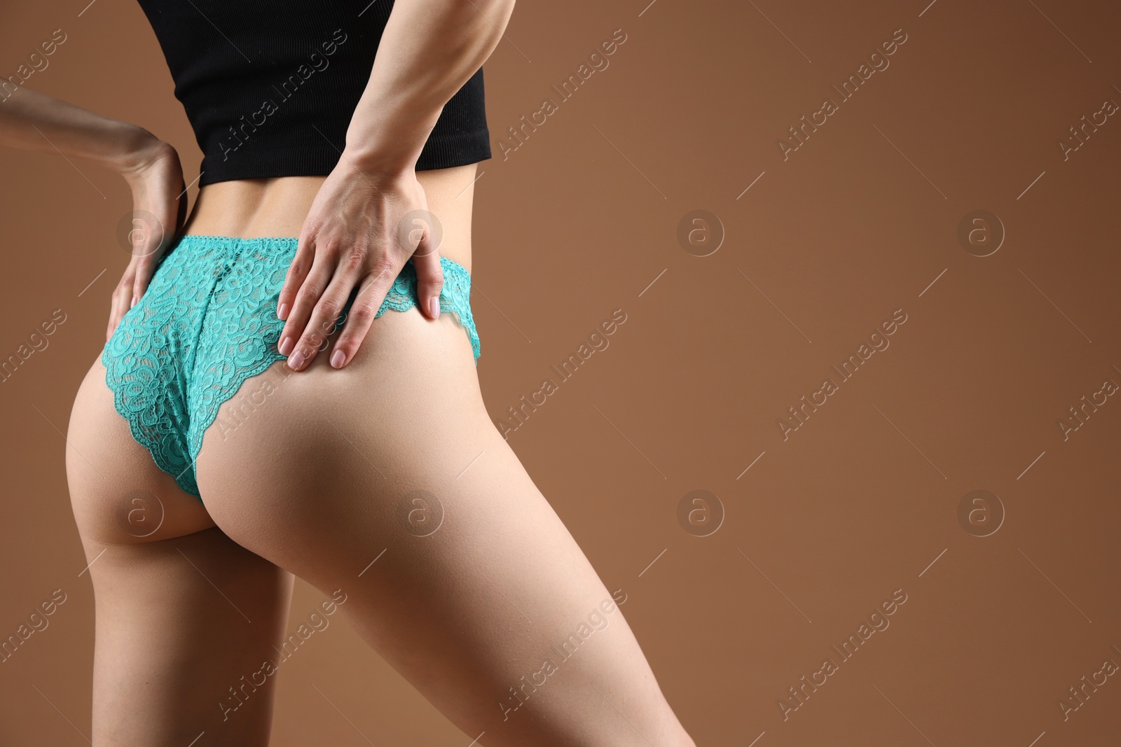 Woman wearing beautiful underwear on brown background, closeup. Space for text Photo of Woman wearing beautiful underwear on brown background, closeup. Space for text