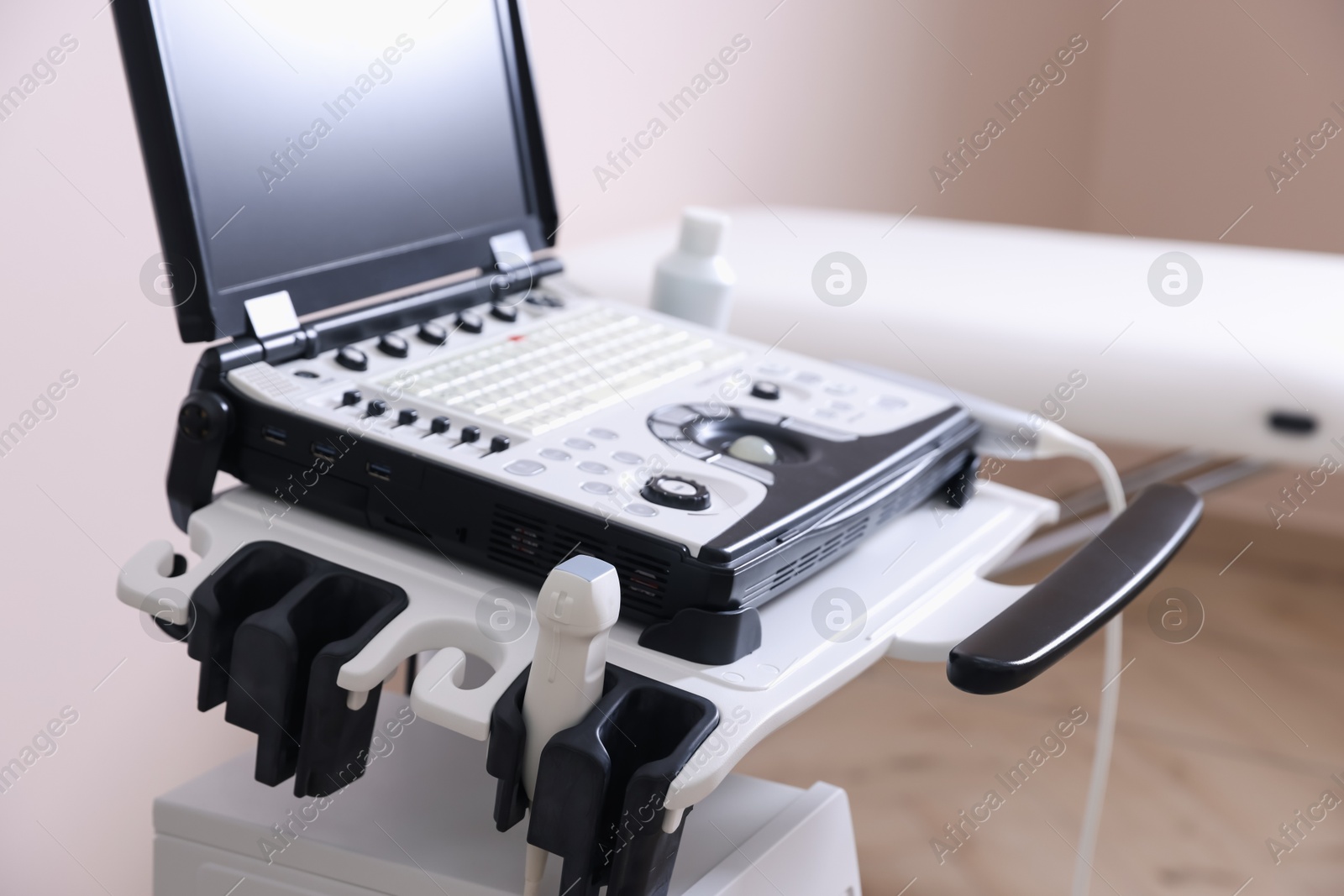 Modern ultrasound machine and examination bed in clinic, closeup Photo of Modern ultrasound machine and examination bed in clinic, closeup