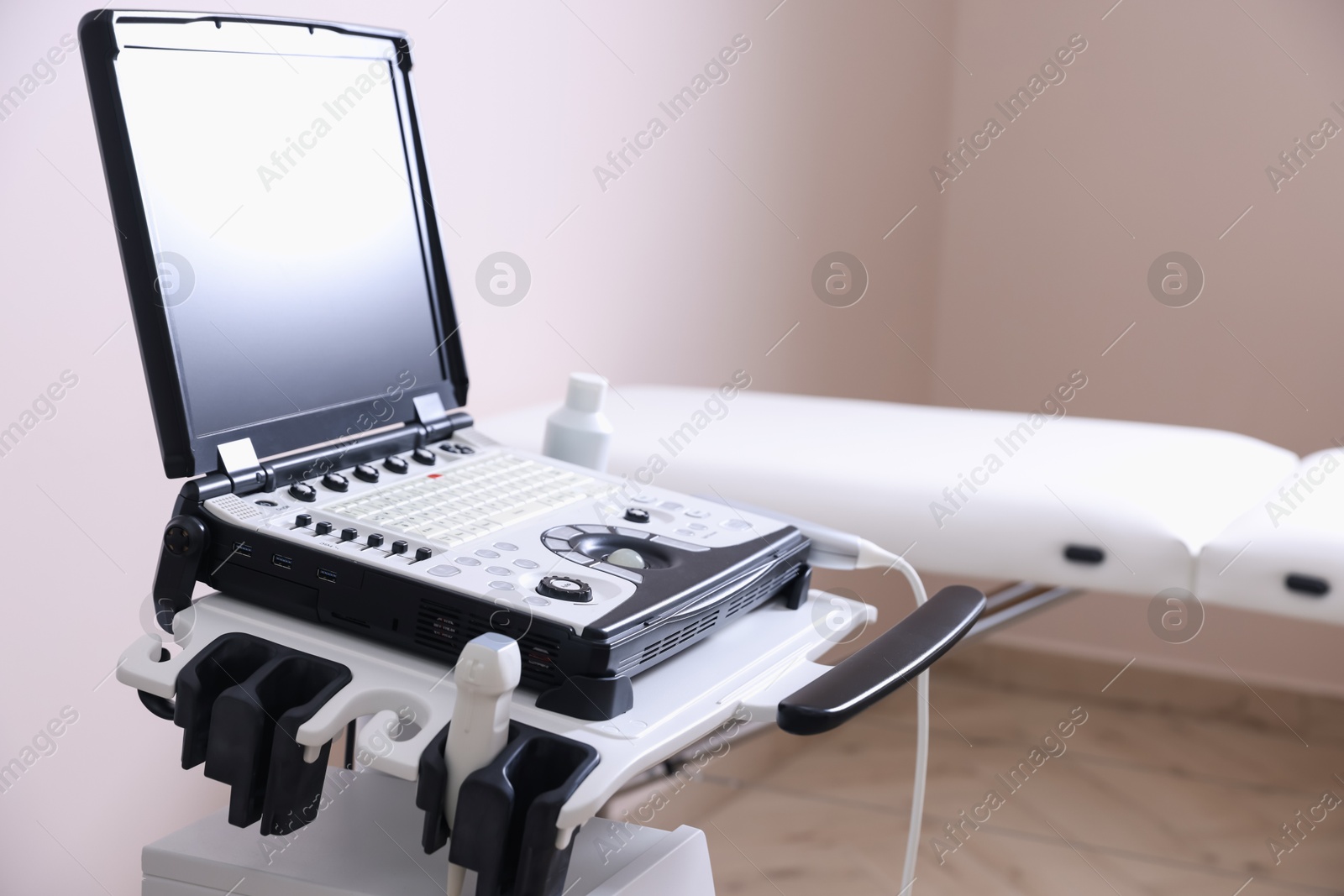 Modern ultrasound machine and examination bed in clinic Photo of Modern ultrasound machine and examination bed in clinic