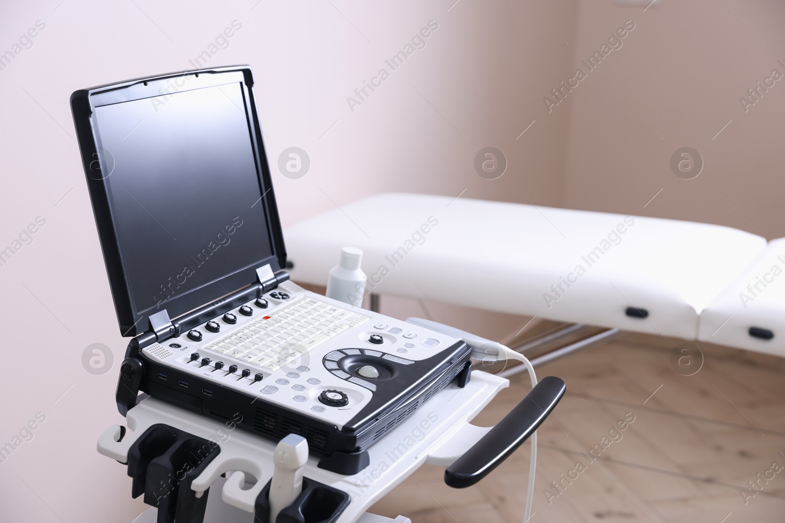 Modern ultrasound machine and examination bed in clinic Photo of Modern ultrasound machine and examination bed in clinic