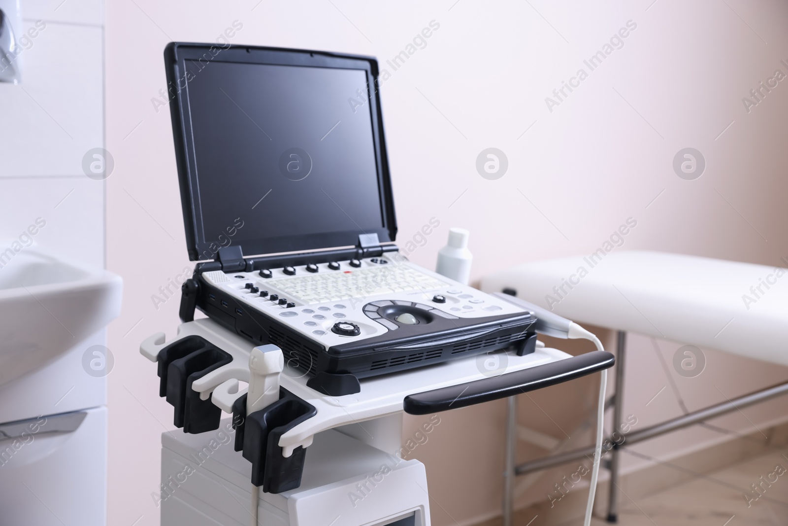 Modern ultrasound machine and examination bed in clinic Photo of Modern ultrasound machine and examination bed in clinic