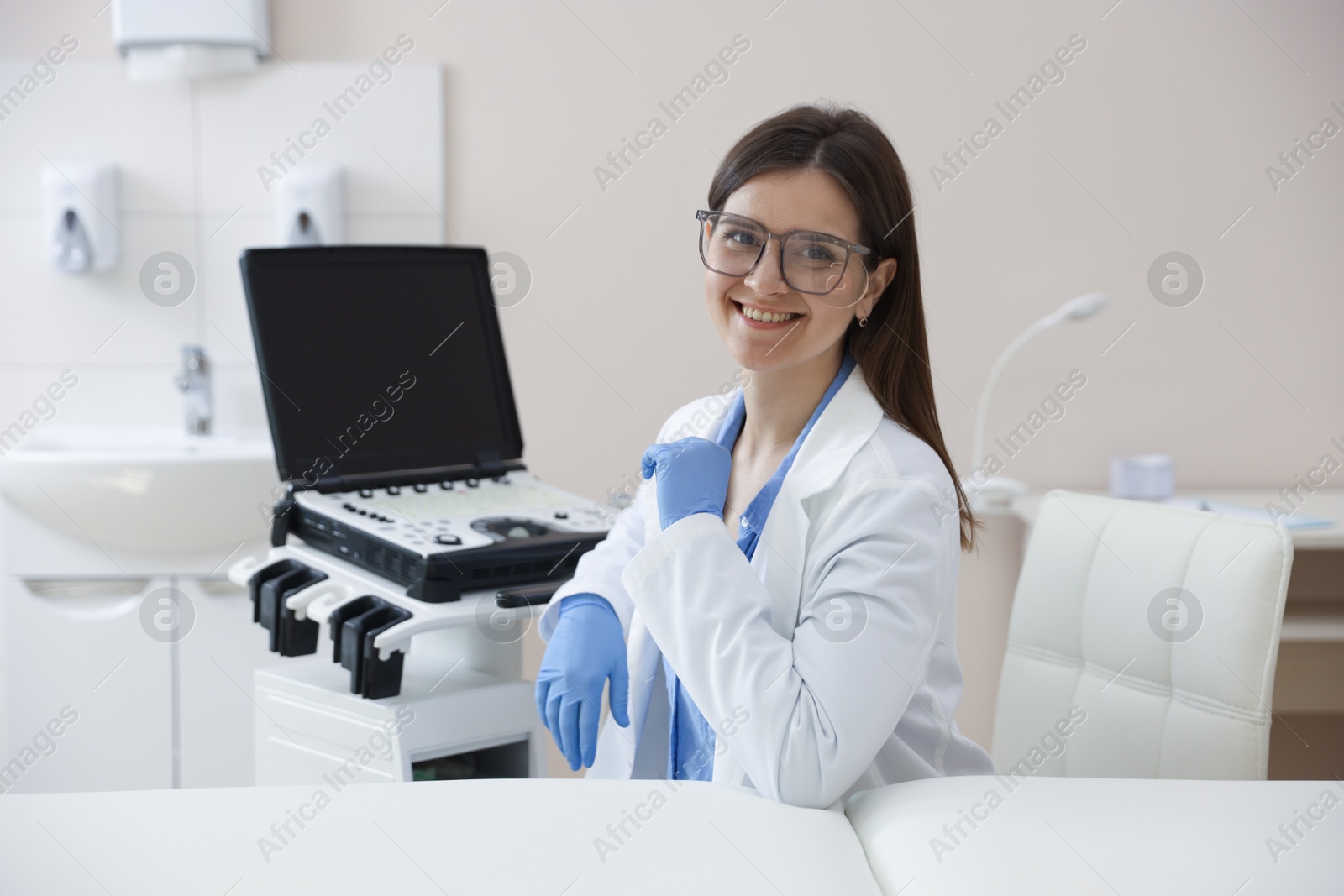 Professional sonographer with ultrasound machine in clinic Photo of Professional sonographer with ultrasound machine in clinic