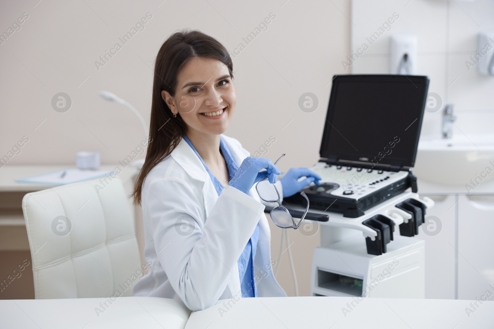 Professional sonographer with ultrasound machine in clinic Photo of Professional sonographer with ultrasound machine in clinic