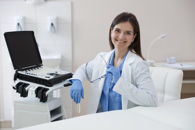 Photo of Professional sonographer with ultrasound machine in clinic