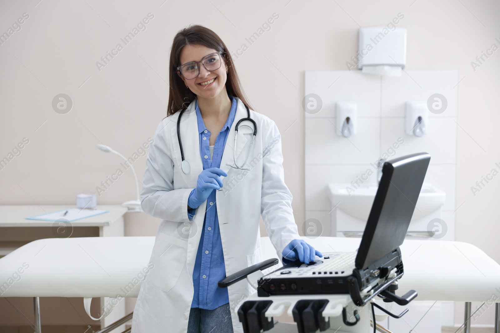 Professional sonographer with ultrasound machine in clinic Photo of Professional sonographer with ultrasound machine in clinic