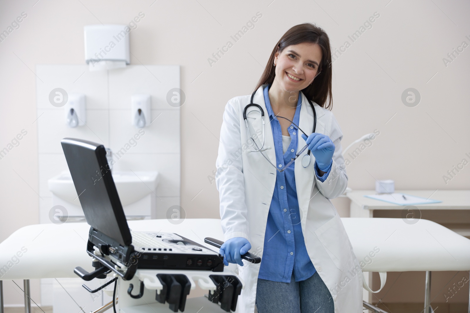 Professional sonographer with ultrasound machine in clinic Photo of Professional sonographer with ultrasound machine in clinic