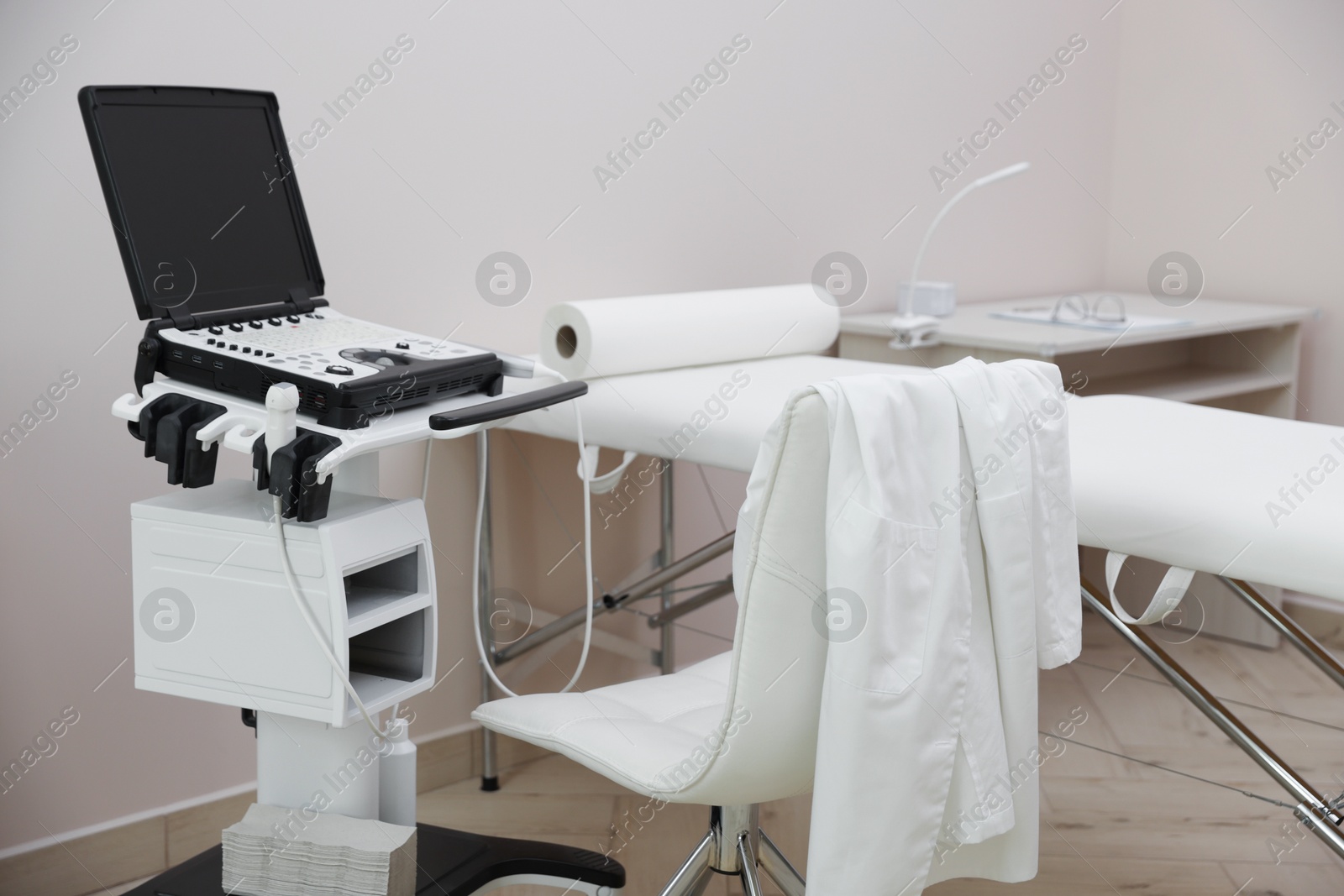 Modern ultrasound machine and examination bed in clinic Photo of Modern ultrasound machine and examination bed in clinic