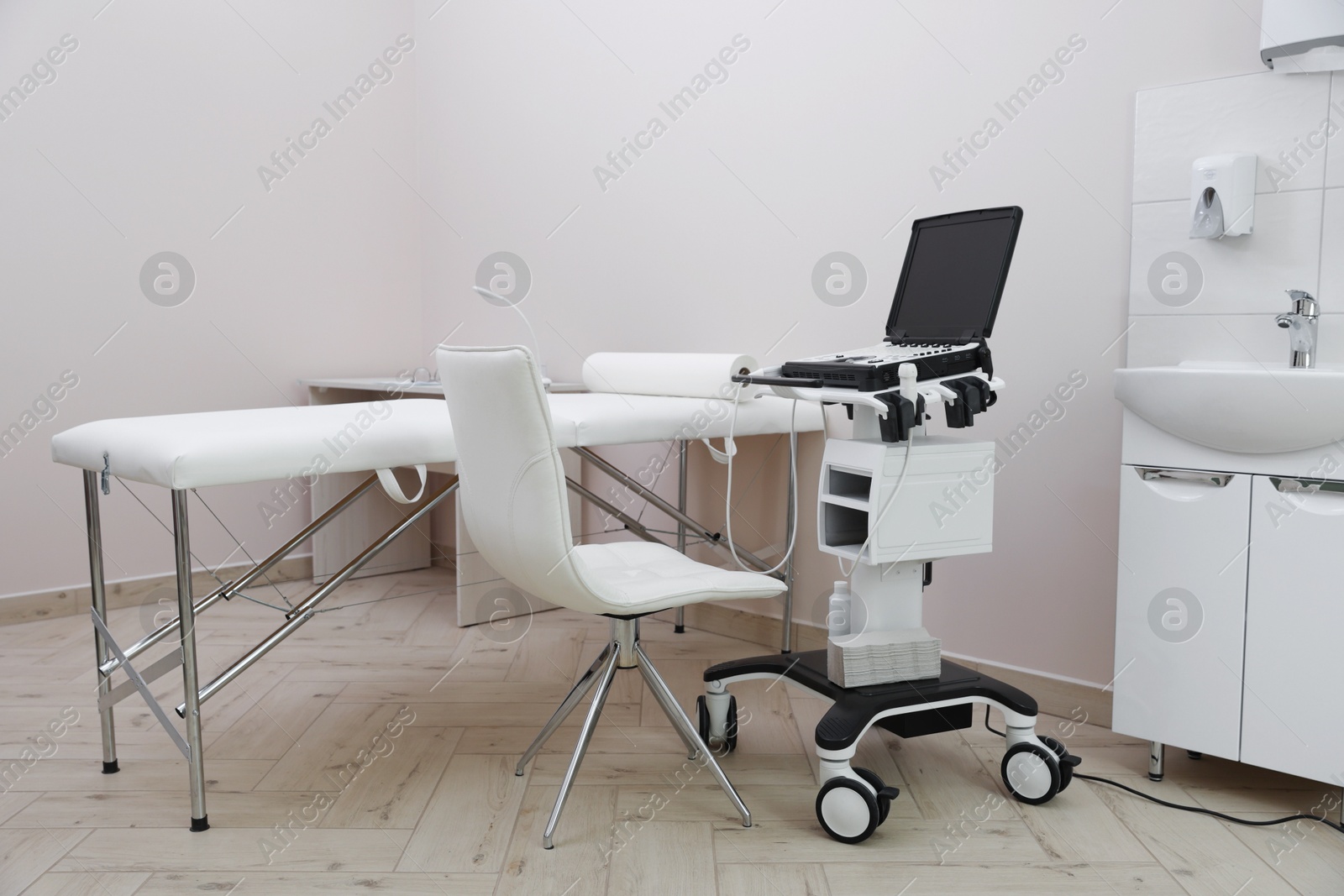 Modern ultrasound machine and examination bed in clinic Photo of Modern ultrasound machine and examination bed in clinic