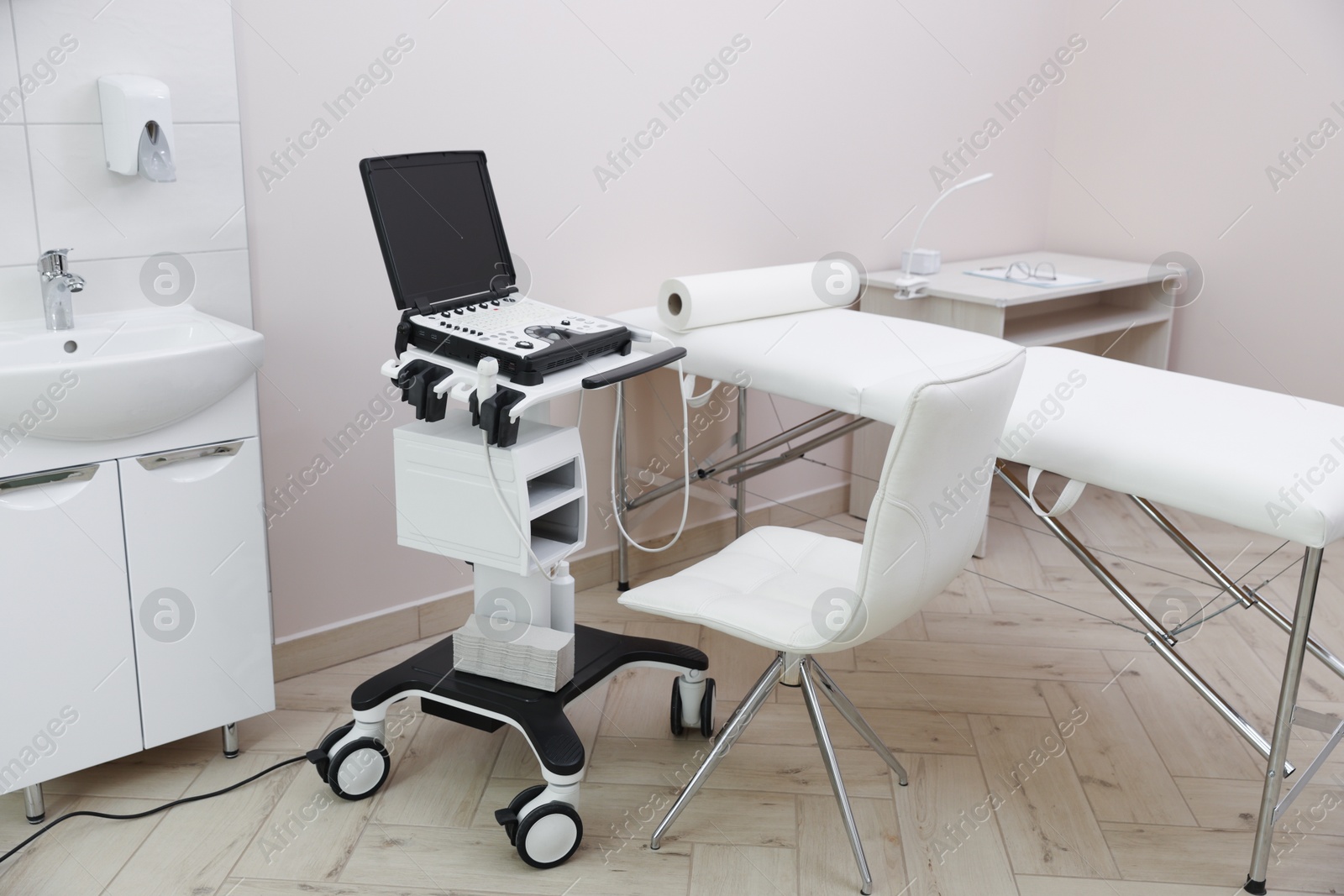 Modern ultrasound machine and examination bed in clinic Photo of Modern ultrasound machine and examination bed in clinic