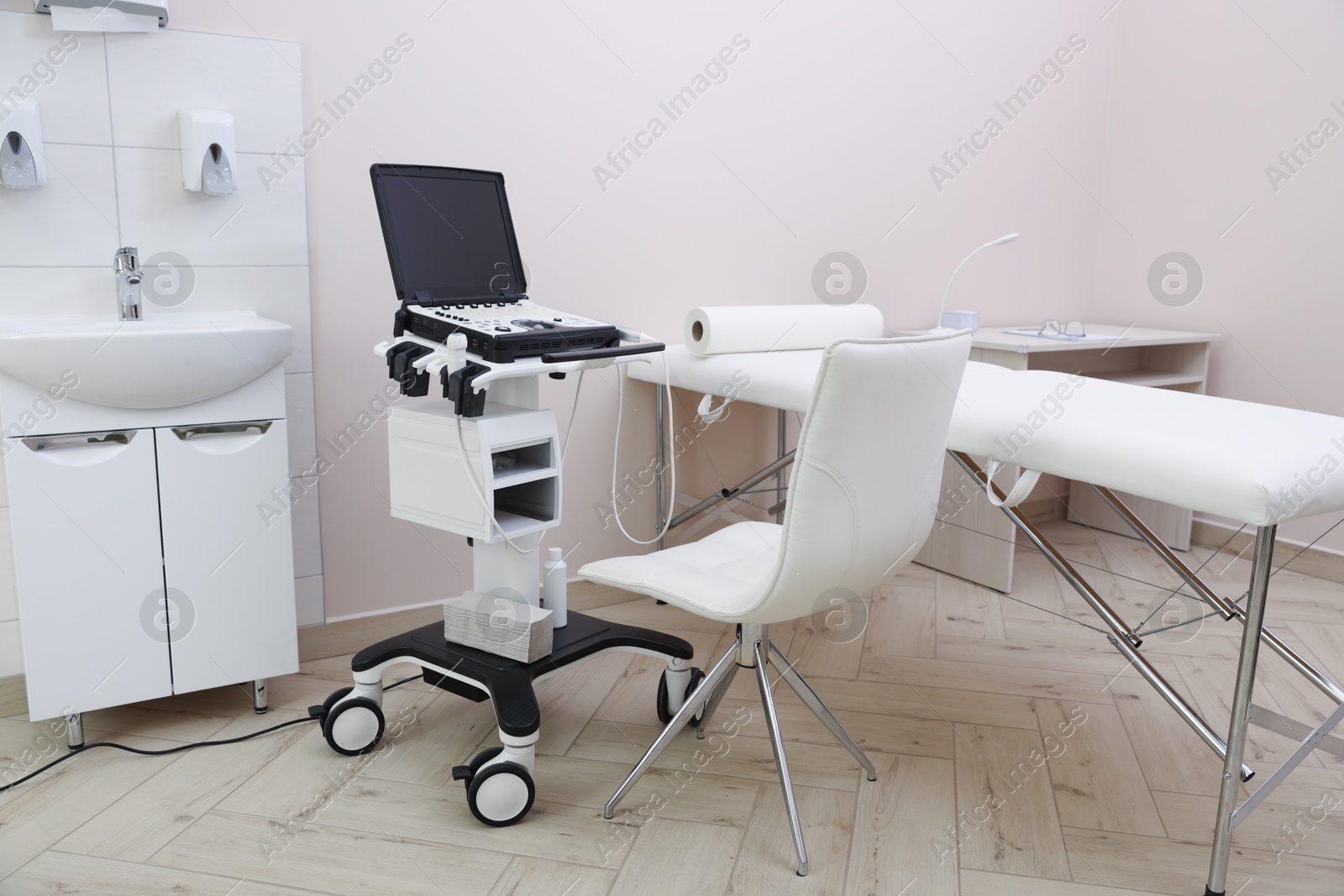 Modern ultrasound machine and examination bed in clinic Photo of Modern ultrasound machine and examination bed in clinic