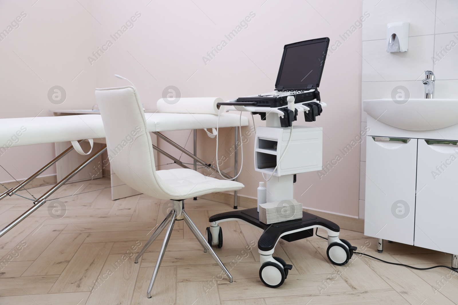 Modern ultrasound machine and examination bed in clinic Photo of Modern ultrasound machine and examination bed in clinic