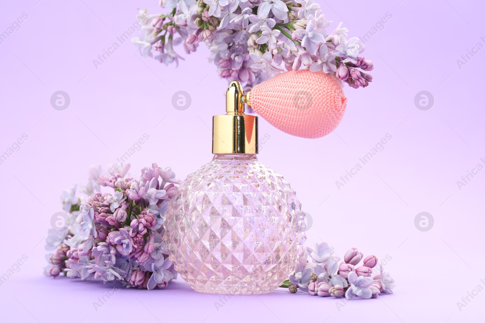 Bottle with perfume and lilac flowers on violet gradient background, closeup Photo of Bottle with perfume and lilac flowers on violet gradient background, closeup