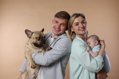 Photo of Happy family with little baby and cute dog on beige background