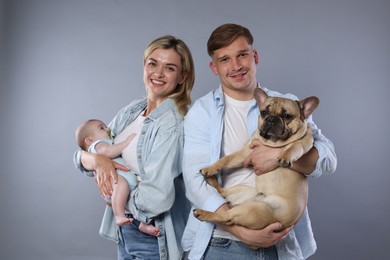 Photo of Happy family with little baby and cute dog on grey background
