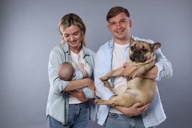 Photo of Happy family with little baby and cute dog on grey background