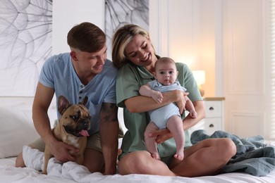 Photo of Happy family with little baby and cute dog on bed at home