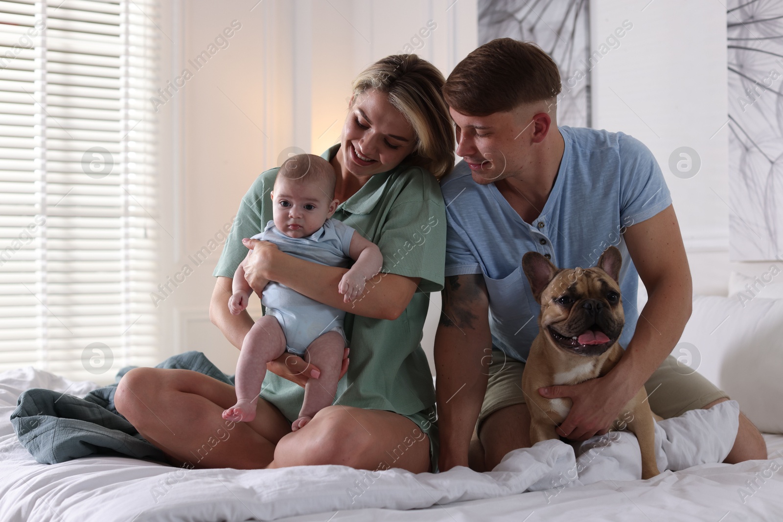 Happy family with little baby and cute dog on bed at home Photo of Happy family with little baby and cute dog on bed at home