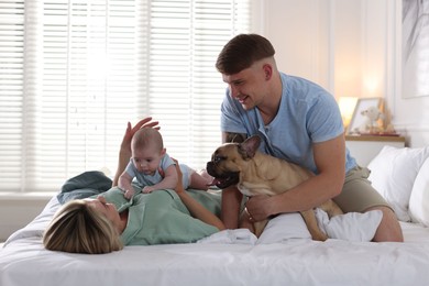 Photo of Happy family with little baby and cute dog on bed at home