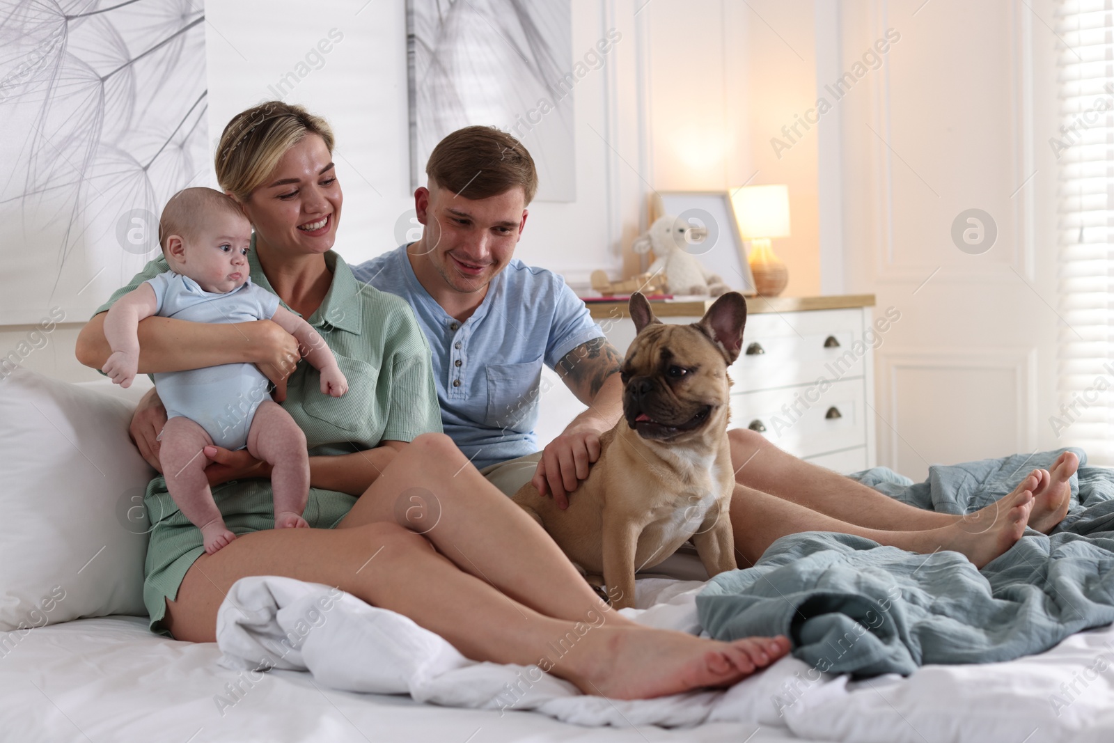 Happy family with little baby and cute dog on bed at home Photo of Happy family with little baby and cute dog on bed at home