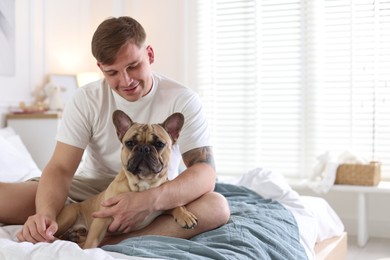 Photo of Man with his cute dog on bed at home. Space for text