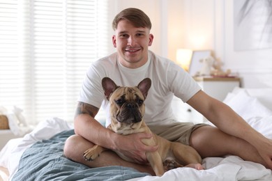 Photo of Man with his cute dog on bed at home