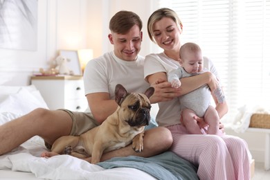 Photo of Happy family with little baby and cute dog on bed at home