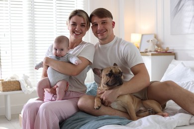 Photo of Happy family with little baby and cute dog on bed at home