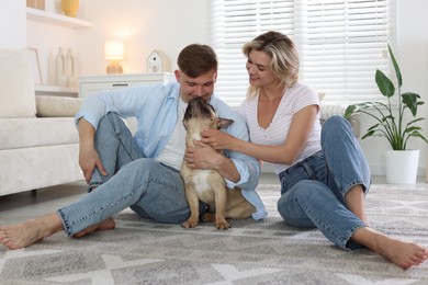 Photo of Happy couple with cute dog at home