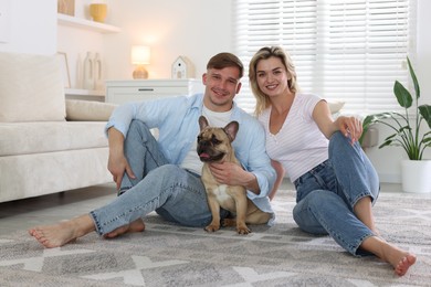 Photo of Happy couple with cute dog at home