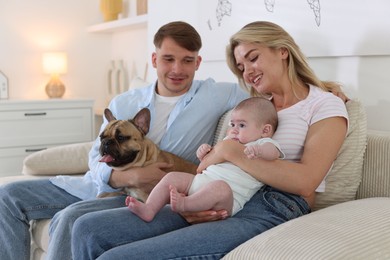 Photo of Happy family with little baby and cute dog on sofa at home