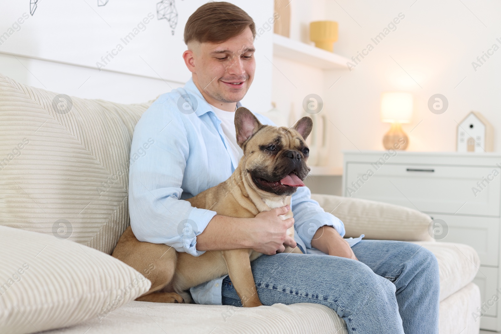 Man and his cute dog on sofa at home Photo of Man and his cute dog on sofa at home