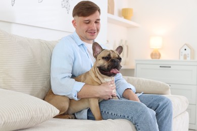 Photo of Man and his cute dog on sofa at home