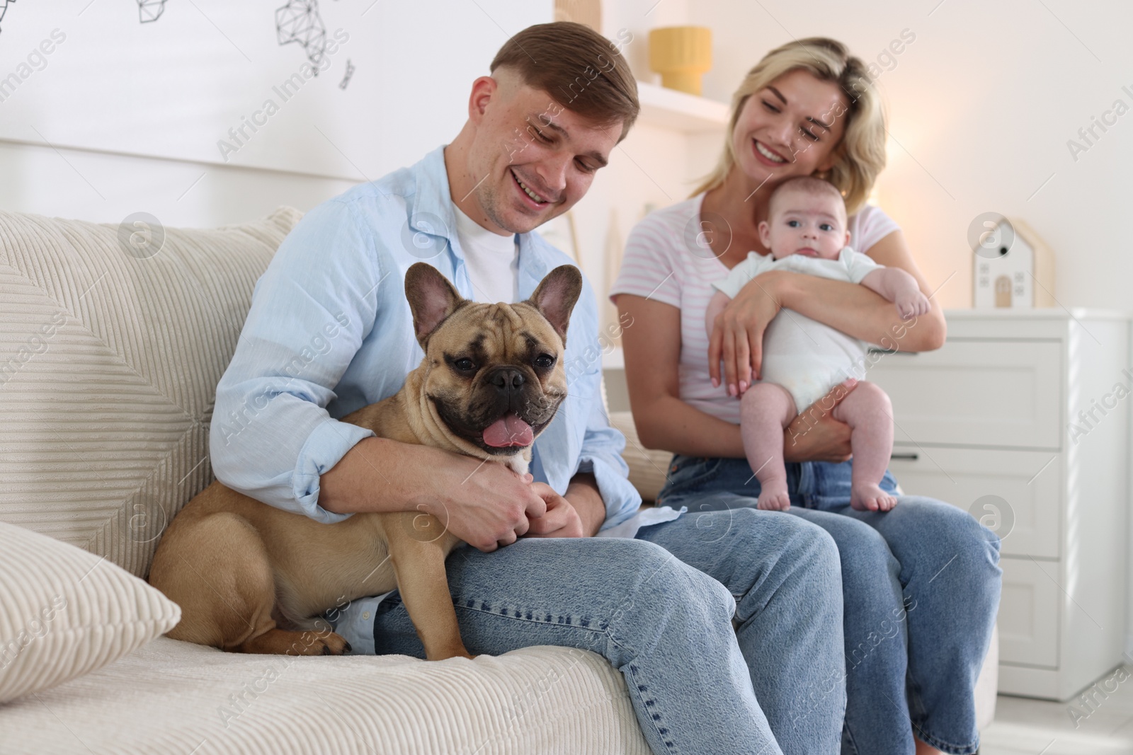 Happy family with little baby and cute dog on sofa at home Photo of Happy family with little baby and cute dog on sofa at home