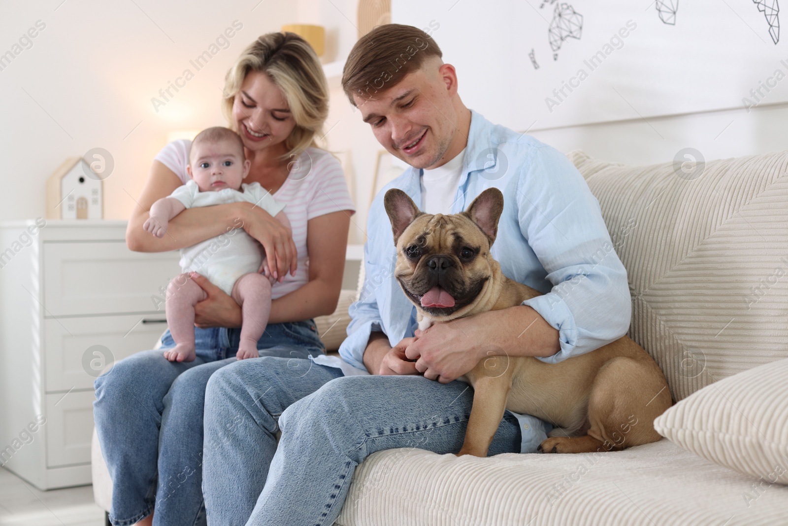 Happy family with little baby and cute dog on sofa at home Photo of Happy family with little baby and cute dog on sofa at home