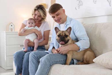 Photo of Happy family with little baby and cute dog on sofa at home