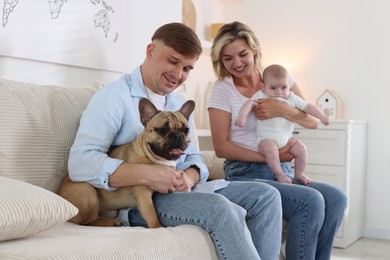 Photo of Happy family with little baby and cute dog on sofa at home
