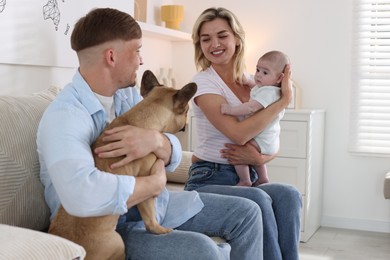 Photo of Happy family with little baby and cute dog on sofa at home