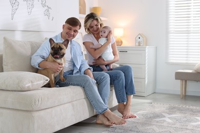 Photo of Happy family with little baby and cute dog on sofa at home. Space for text
