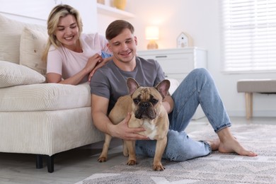 Photo of Happy couple with cute dog at home