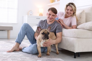 Photo of Happy couple with cute dog at home