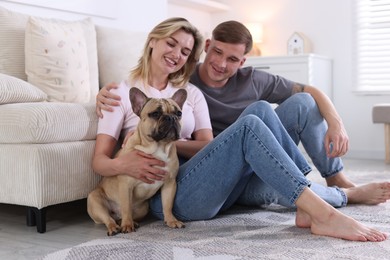 Photo of Happy couple with cute dog at home