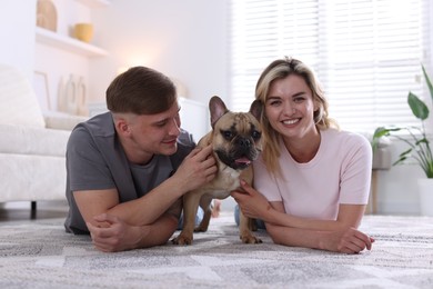 Photo of Happy couple with cute dog at home