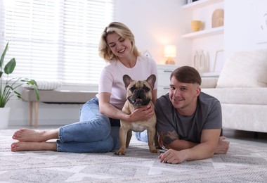 Photo of Happy couple with cute dog at home